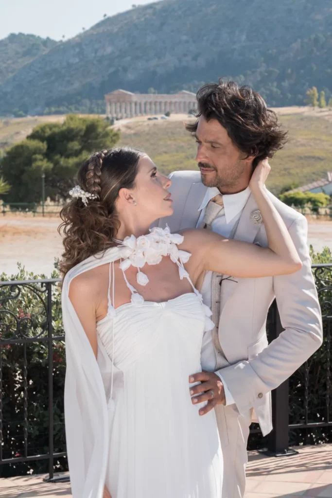 Sposo in abito chiaro e sposa davanti al tempio di Segesta